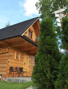 a wooden cabin with a table and a sign at Misia Chata in Zakopane