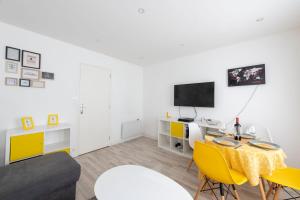 een woonkamer met een tafel en gele stoelen bij Your Place in LH in Le Havre