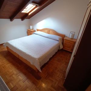a bedroom with a bed and a wooden floor at La Mansarda di Sabina. in Fiera di Primiero
