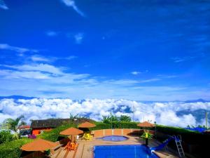 Blick auf einen Pool mit Sonnenschirmen in der Unterkunft Paraíso Tropical in Aguadas