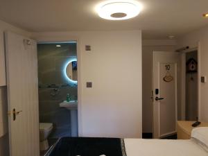 1 dormitorio con 1 cama y baño con ducha en Motel Schmotel, en Brighton & Hove
