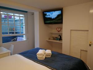 1 dormitorio con 2 toallas en una cama y TV en Motel Schmotel, en Brighton & Hove