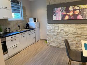 a kitchen with a tv hanging on a brick wall at Gabrielle2 apartman in Debrecen