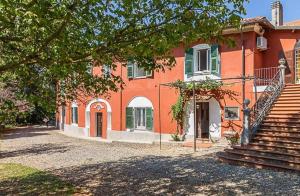 una gran casa naranja con escaleras delante en Charme of Villa Capannina en Novi Ligure
