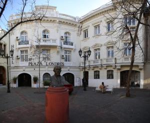 een groot gebouw met een standbeeld ervoor bij Hostal Plaza Londres 77 in Santiago