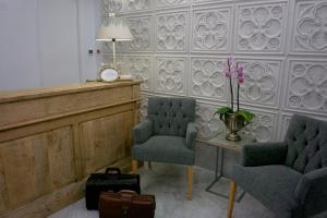 a court room with two chairs and a table and a clock at Hostal Boutique Aurora in Nerja