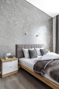 sypialnia z dużym łóżkiem z betonową ścianą w obiekcie InshiApartments on Popovycha str w Lwowie
