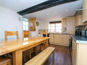 a kitchen with a wooden table and a counter top at IRONBRIDGE - 18th CENTURY THREE BEDROOM COTTAGE - 6 BEDS in Ironbridge