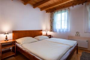 een slaapkamer met een groot bed met witte lakens en een raam bij Chatka TATRALANDIA 439 in Liptovský Mikuláš