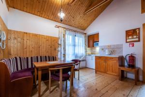 een keuken met een tafel en stoelen in een kamer bij Chatka TATRALANDIA 439 in Liptovský Mikuláš