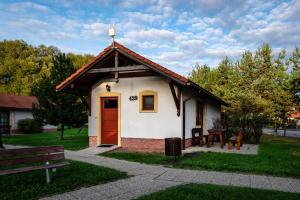 una pequeña casa con una puerta roja en un parque en Chatka TATRALANDIA 439, en Liptovský Mikuláš