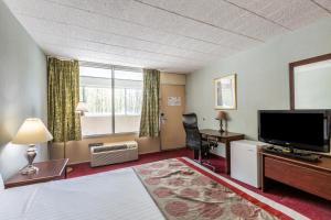 a hotel room with a bed and a flat screen tv at Red Carpet Inn & Suites in Hazleton