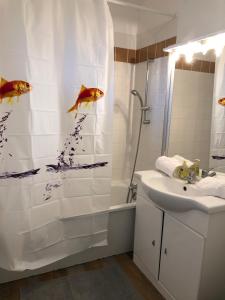uma casa de banho com uma cortina de chuveiro com peixe em Studio avec piscine aux portes d’Honfleur em Honfleur