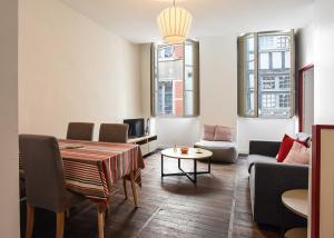 una sala de estar con una mesa y un sofá en Bayonne en plein cœur Centre Historique 2 chambres, en Bayona