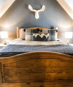 a bedroom with a wooden bed with two lamps at Riverfront Mountain Cottage Retreat in Estes Park