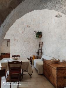 Zimmer mit einem Tisch, Stühlen und einer Steinmauer in der Unterkunft Truly Home Short Lets in Locorotondo