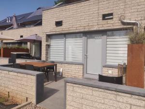 un patio avec une table et un bâtiment dans l'établissement Terrasses de Malmedy Studio 331-BOLY, à Malmedy