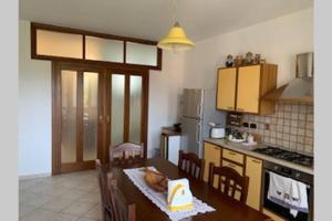 a kitchen with a table and chairs and a kitchen with at CASA VACANZA in Chiaravalle Centrale