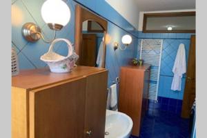 a bathroom with a sink and a toilet and blue walls at CASA VACANZA in Chiaravalle Centrale