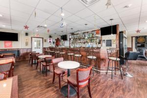 bar w restauracji ze stołami i krzesłami w obiekcie Red Carpet Inn & Suites w mieście Hazleton