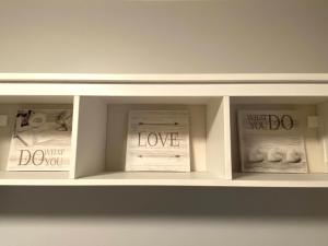 a white shelf with pictures on it with the words love at Vilnius central studio apartment in Vilnius