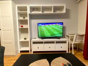 a living room with a tv on a white entertainment center at Vilnius central studio apartment in Vilnius