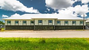 a large white building with a blue roof at Everglades Adventures Hotel Suites by Ivey House in Everglades City