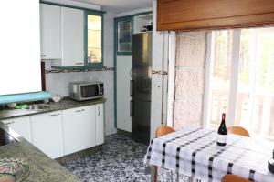 - une cuisine avec une table et une bouteille de vin dans l'établissement Mar y Montaña en Las Rías Baixas, à Gondomar