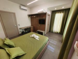 Un dormitorio con una cama verde con una toalla. en QUEEN MEDINA Centro Storico en Nápoles