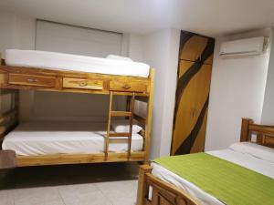 a room with two bunk beds and a mirror at Hostal Casa Roma in Taganga