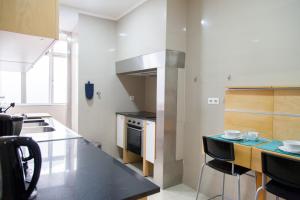 - une cuisine avec un comptoir et une cuisinière four supérieur dans l'établissement FLH Madragoa Fresh Design Apartment, à Lisbonne