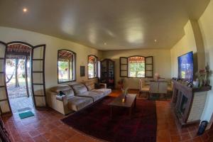 a living room with a couch and a fireplace at Pousada e Restaurante Refúgio Dinamarca in Mairiporã