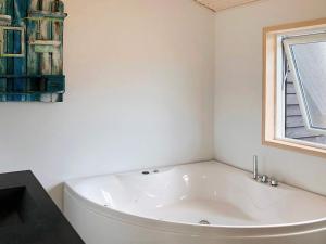 een badkamer met een wit bad en een raam bij 10 person holiday home in Ansager in Ansager