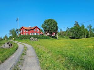 een rood huis op een heuvel met een onverharde weg bij 5 person holiday home in Mell sa in Mellösa