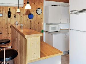 a kitchen with a counter with a microwave and a refrigerator at 4 person holiday home in Hvide Sande in Bjerregård