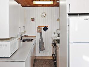 a white kitchen with a sink and a refrigerator at 4 person holiday home in Hvide Sande in Bjerregård