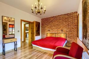 - une chambre avec un lit rouge et un mur en briques dans l'établissement Jerzwałd 14, à Jerzwałd