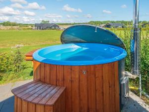 eine große Holzbadewanne mit blauem Wasser in der Unterkunft 10 person holiday home in Odder in Odder