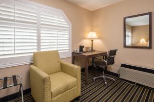 a room with a chair and a desk and a mirror at Travel Inn Sunnyvale in Sunnyvale