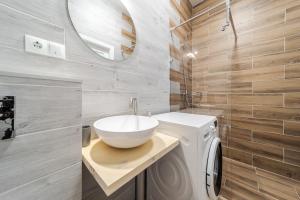 a bathroom with a sink and a washing machine at InshiApartments on Popovycha str 2 in Lviv +9 photos