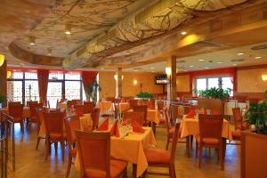 a dining room with tables and chairs with yellow table cloth at PRIMAVERA Hotel & Congress centre in Pilsen