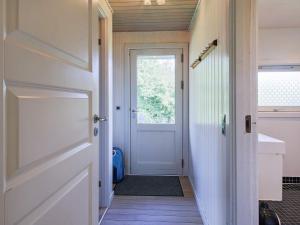 un pasillo con una puerta blanca y una ventana en 6 person holiday home in J gerspris, en Hornsved