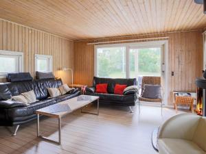 ein Wohnzimmer mit Ledersofas und einem Tisch in der Unterkunft 6 person holiday home in J gerspris in Hornsved