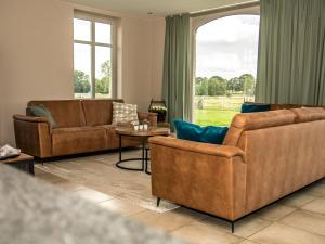 ein Wohnzimmer mit braunen Möbeln und einem großen Fenster in der Unterkunft Serene Mansion in Peer with Terrace in Peer