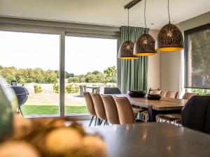 une salle à manger avec une table, des chaises et une grande fenêtre dans l'établissement Serene Mansion in Peer with Terrace, à Peer