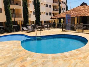 a large swimming pool in the middle of a building at Apto a 3 minutos do Thermas!! in Olímpia
