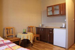 a kitchen with a table and chairs and a kitchen with a refrigerator at Nasz Domek in Karpacz