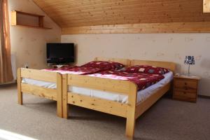 a bedroom with a large wooden bed with a television at Nasz Domek in Karpacz