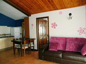 sala de estar con sofá, mesa y cocina en Serrania - Apartamentos El Cabo, en Las Majadas