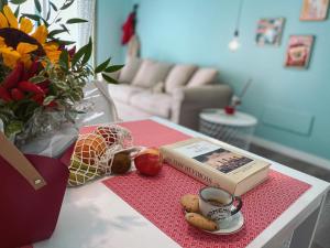 a table with a book and an apple and a cup of coffee at WellHome Asti Premium Apartments with Private Terrace & Garden in Asti